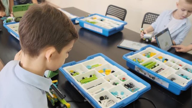 Close up view of teenage guy investigates how to construct the plastic mechanism at the e-learning class slow motion