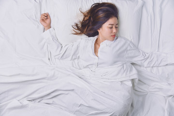 Young Woman Sleeping In Bed. Top view of young woman lying down sleeping well in bed. sleeping relax, young smiling pretty lady lies in bed.