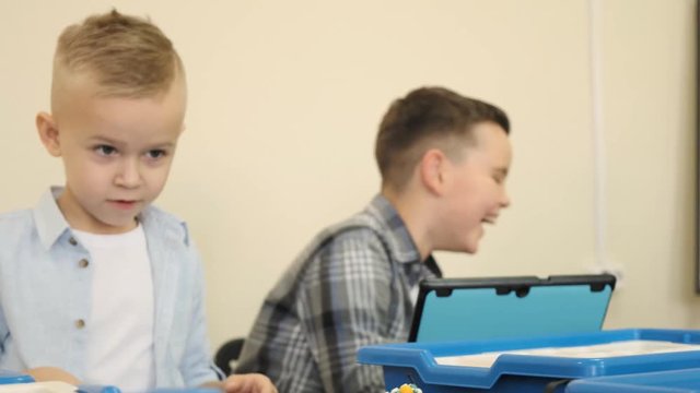 Happy childred learn the engineering process at the programming class using ipads slow motion