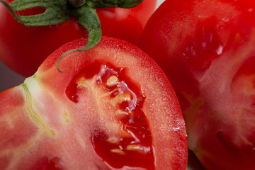 Fresh, ripe tomato, cut in half, juicy, still with green stem, close up
