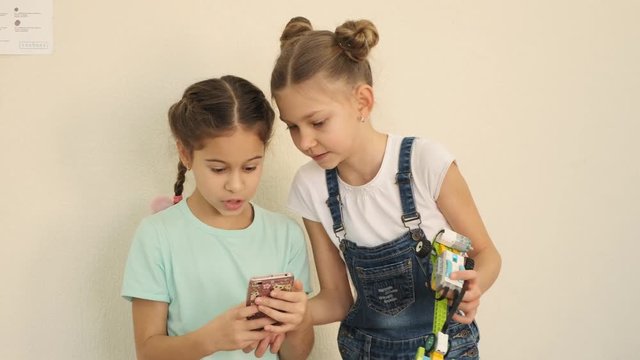 Two nice girls check if they made good selfie with electronical topys constructed at the e-learning lesson slow motion