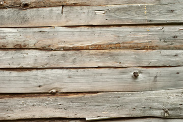 Old distorted boards in a row on the wall. Texture of natural rough boards.