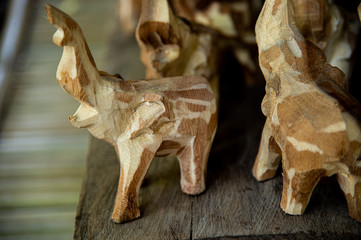 Fototapeta premium Beautiful various of elephants wooden carving from teak and amazing carve art work on the old wood table background.