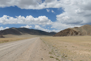 Fototapeta na wymiar Western Mongolia steppe landscape. Dirt road between Russian border and Tsagaannuur town. Bayan-Ulgii Province, Mongolia.