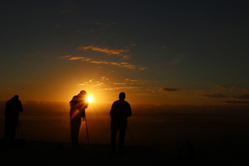silhouette of man on top of mountain at sunset