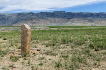 Western Mongolia steppe landscape. Ancient stone stele. Outskirts of Tsengel village, Bayan-Ulgii Province, Mongolia.