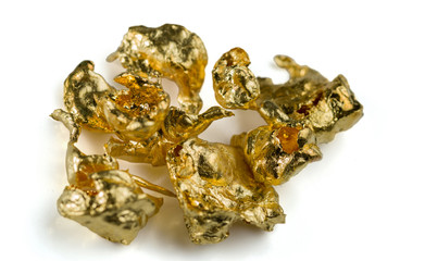 A few gold nuggets isolated on white background. Selective focus.