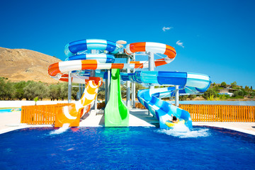 colorful open-air water slides with a rearward-facing child, front view