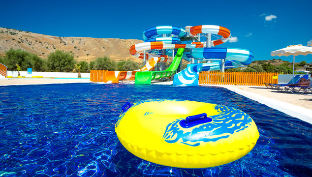 colorful open-air water slides with a yellow inflatable circle for downhill sliding, wide angel