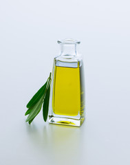 Carafe with olive oil and olive twig from olive tree. Isolated on white