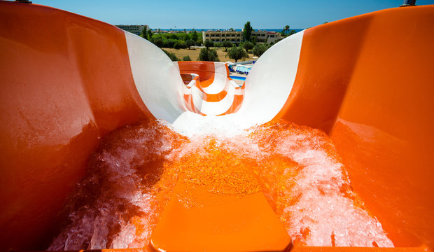 start position on water slide, orange tobogan, , in the background hotel and sea