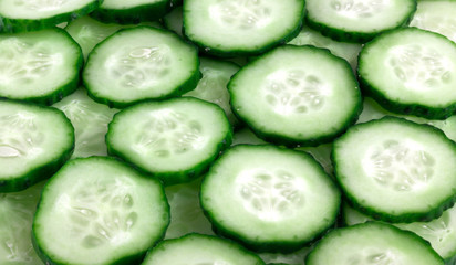 Fresh green cucumbers sliced. Several sliced cucumbers stacked on top of each other.