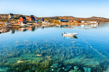 Beautiful sea coast and colorful houses on the rocks in Oqaatsut village, western Greenland. Summer greenlandic landscape © smallredgirl
