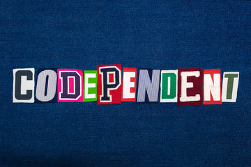 CODEPENDENT word text collage, multi colored fabric on blue denim, mental health concept, horizontal aspect