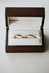 Golden wedding rings in brown wooden box.
