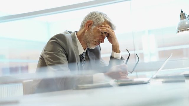 Tired businessman sitting at desk