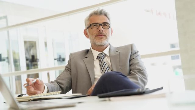Relaxed corporate businessman sitting at desk
