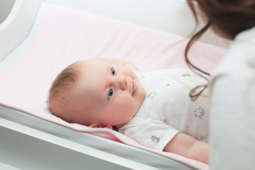 3 Month Old Cute Baby Girl, Infant ,lying on the white chanting table, laughs, looking on her Mother, New family concept, The most Beautiful Baby Princesse, Happy Baby Girl