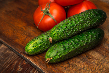 Fresh cucumbers, tomatoes on the kitchen table. Fresh harvest. Copy space