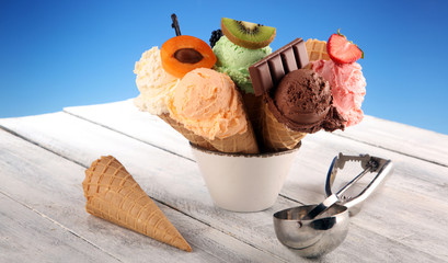 ice cream scoops of different colors and flavours with berries, nuts and fruits decoration on white background