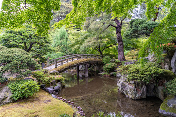 Beautiful scenery at the Kyoto Imperial Palace, the Gonaitei Garden,with a pond and bridges. On a rainy day, droplets are visible in the air.