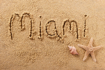 Miami word written in sand on a sunny florida summer beach with starfish holiday vacation travel destination sign writing message photo