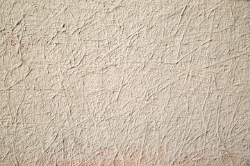 Textural background, plaster with a pile effect painted in beige color.