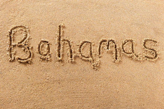 Bahamas word written in sand on a sunny summer beach holiday vacation travel destination sign writing message photo