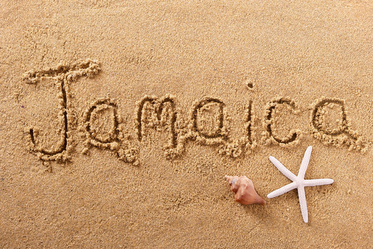 Jamaica word written in sand on a sunny summer beach with starfish holiday vacation travel destination sign writing message photo