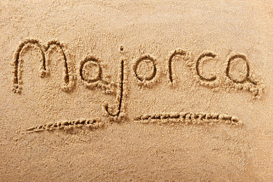 Majorca mallorca word written in sand on a sunny spanish island summer beach holiday vacation travel destination sign writing message photo