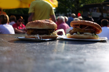 Organic Burger on street food festival in hand. Pulled pork or burger are sold on Open kitchen food...