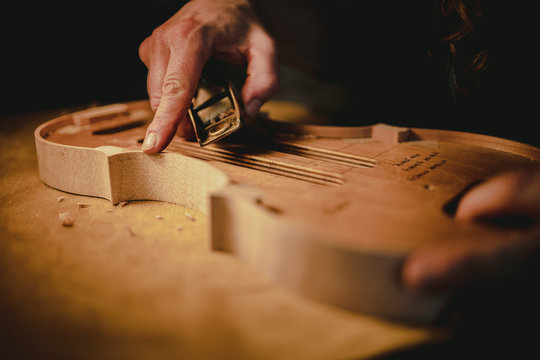Hands of the luthier working on the violin