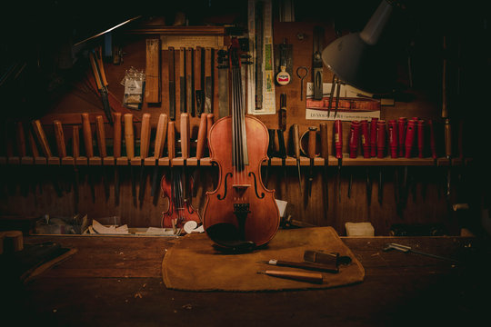 A violin being assembled on a wooden table