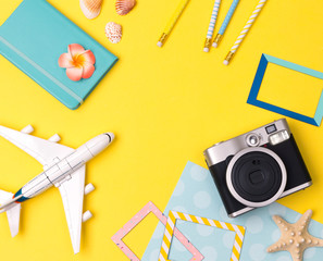 Flat lay travel accessories on yellow background with space for text.