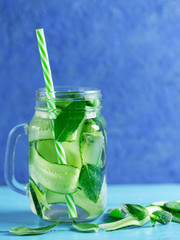 Cucumber infused water with mint on wooden blue background