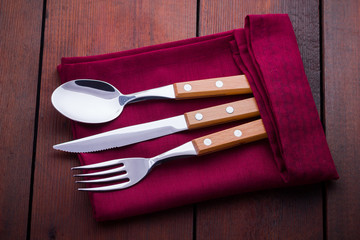Rustic set of cutlery knife, spoon, fork. Сutlery with burgundy napkin and twine. Wooden...