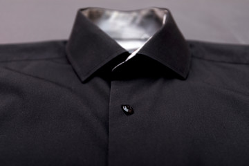 Black shirt on grey background.
