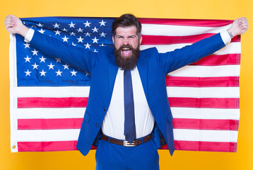 American by birth. Rebel by choice. Confident businessman handsome bearded man in formal suit hold flag USA. Successful businessman well groomed appearance. Business people. Businessman concept