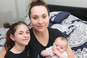 Close up portrait of Young Beautiful Mother with two daughters, Cute 3 Month Old Baby Girl , 7 Years Old Girl, Happy Family, Happy Mother’s Day, Best Mother Concept, The Most Beautiful Girls in the wo