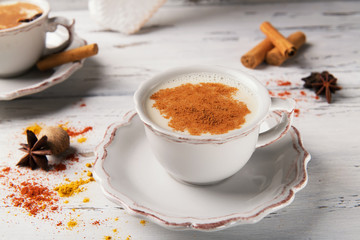 Traditional indian hot drink masala tea with spices on wooden background with ingredients