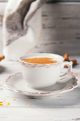 Beautiful cup of traditional indian masala chai tea on with star anise and cinnamon on a shabby wooden texture background