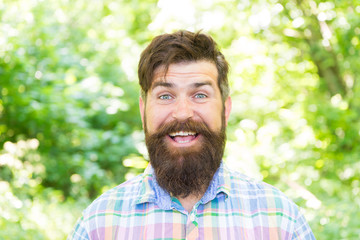 Fototapeta premium Hike and travel. Summer vacation concept. Man bearded hipster green trees background. Guy relax in summer nature. United with environment. Handsome lumberjack. Man beard and mustache in summer forest