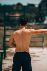 Sporty athletic man with muscular body exercising on sand