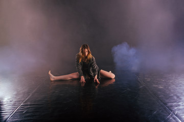 Shoeless female dance shows off her modern art dance moves while looking serious and devoted.