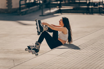 Urban girl tying laces on inline skates