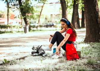 Girl relaxing after daily rollerskating in the city park