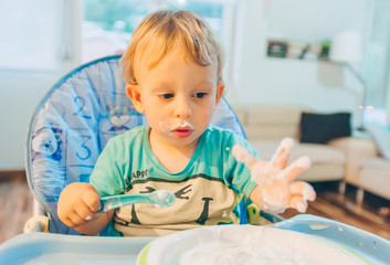 Messy kid eating breakfast