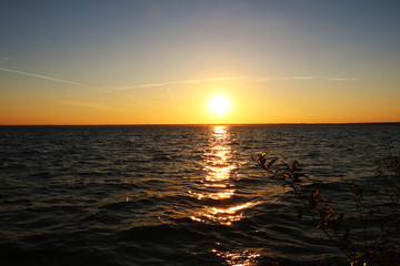 Fototapeta na wymiar Beautiful sunset on the shore of a blue calm lake