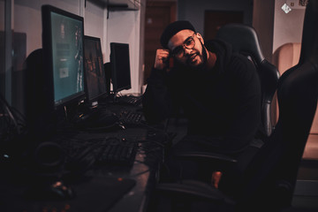 Portrait of tired afroamerican gamer at internet club wich is taking a break between videogames.