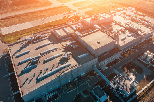 Aerial view of warehouse storages or industrial factory or logistics center from above. Aerial view of industrial buildings and equipment at sunset